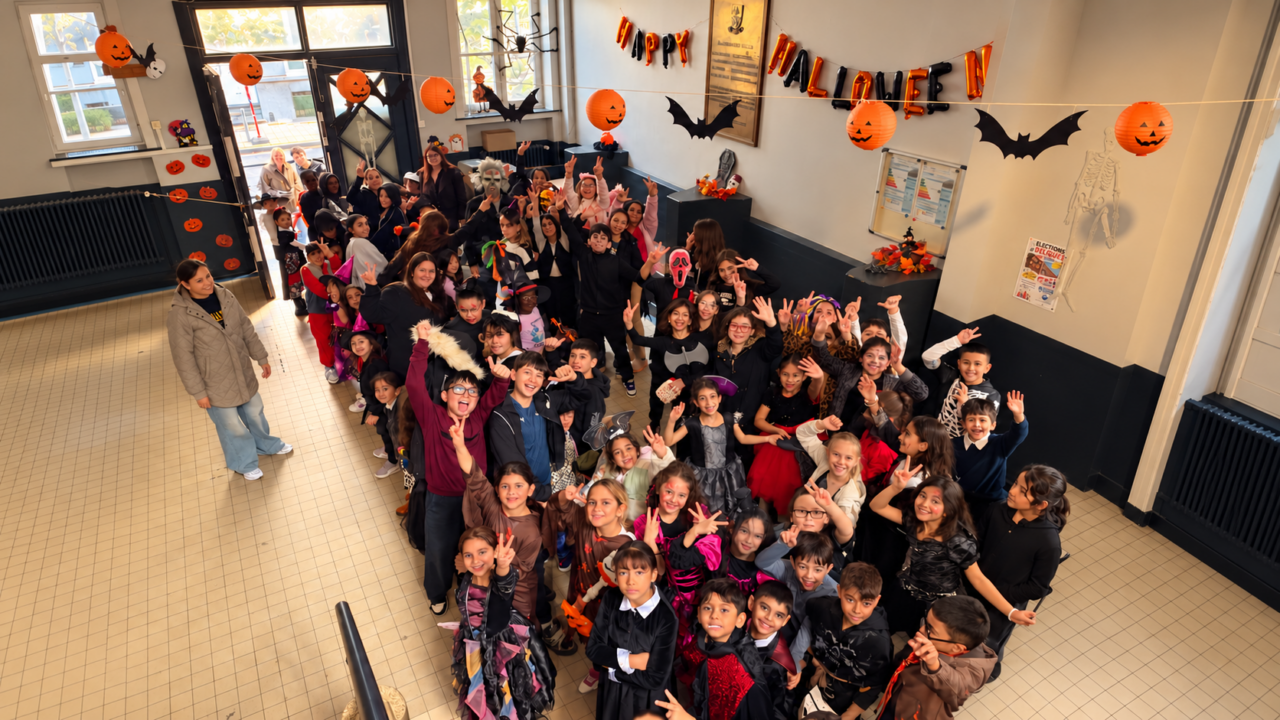 Les enfants fêtent Halloween dans le hall de l'école